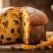 Panettone italien traditionnel posé sur une table en bois, croûte dorée saupoudrée de sucre glace