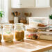 Cuisine lumineuse avec bocaux en verre, plats maison et boîtes hermétiques soigneusement rangés sur un plan de travail.